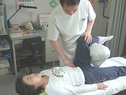 佐野カイロの施術風景。腰椎、骨盤の前側に付いている腸腰筋という筋肉を調整しています。