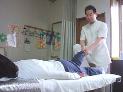 長野県下伊那郡のカイロ整体院、佐野カイロの施術紹介。自然形体療法の手法を使い、骨盤の調整をしている様子です。